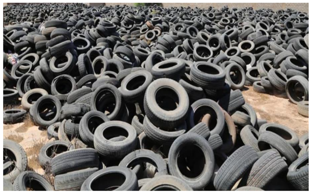 Image: Piles of discarded rubber tires in a landfill, highlighting the environmental impact of traditional disposal methods and the need for sustainable solutions like rubber aggregate surfacing.