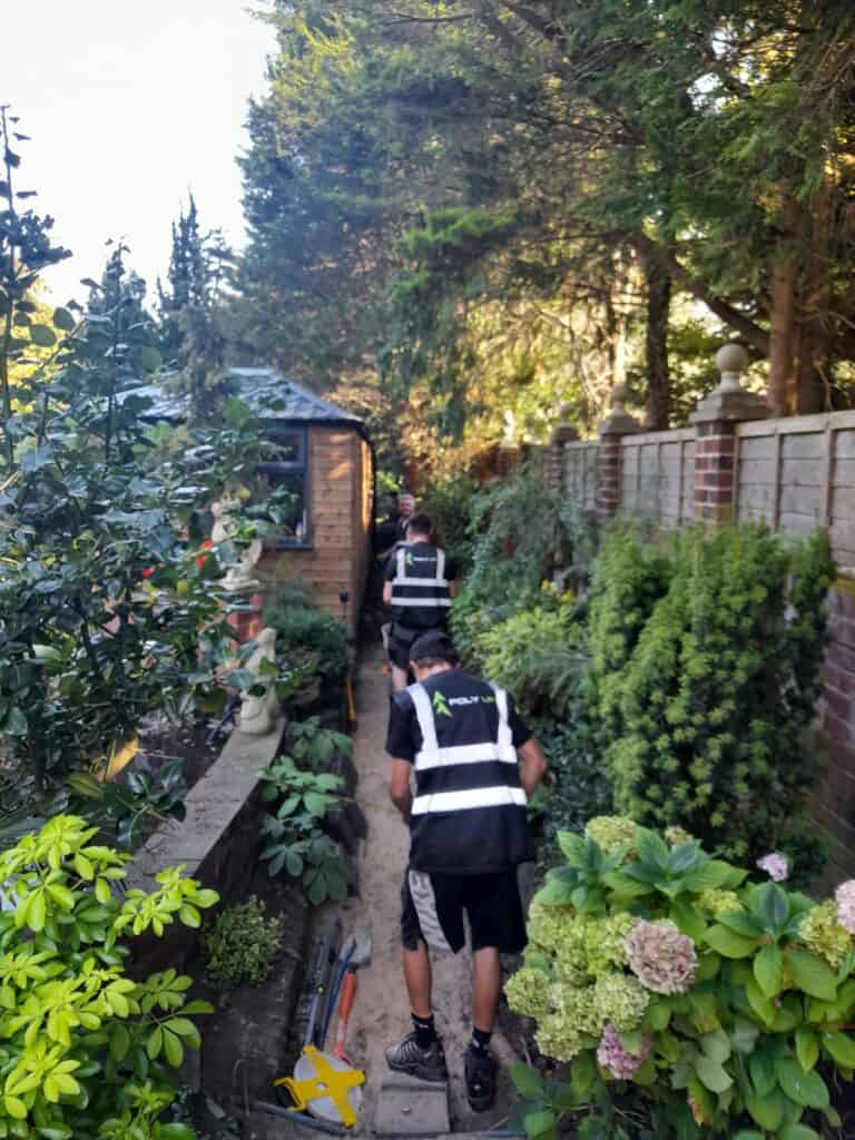 Members of the Poly UP Ltd team expertly excavating an existing tarmac pathway, using professional tools and equipment to carefully prepare the ground for a new resin bound surface installation.